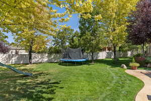 Fenced backyard with a trampoline