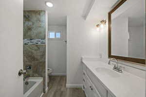 Full bath with vanity, dark wood finished floors, recessed lighting, and shower / washtub combination