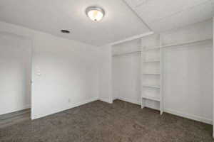Unfurnished bedroom with dark colored carpet and a closet