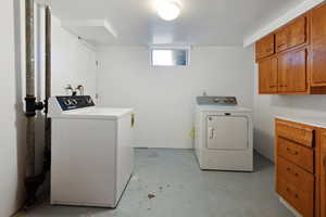 Washroom featuring washer and clothes dryer and cabinet space