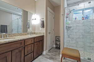 Bathroom featuring a shower stall and double vanity