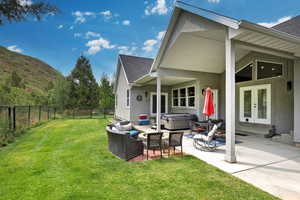 Fenced backyard with a patio, a hot tub, and french doors