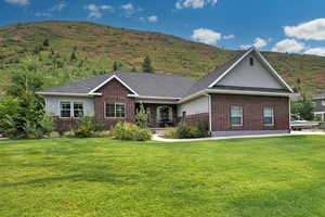 Ranch-style house with brick siding, a front lawn, and a shingled roof