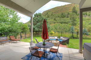 Fenced backyard with a patio, a view of trees, an outdoor living space, and outdoor dining space