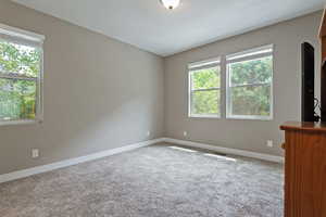 Carpeted spare room with baseboards