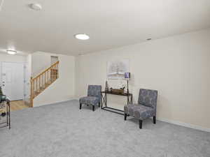 Living area with stairway and carpet