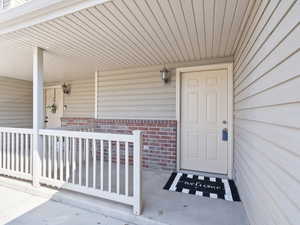Property entrance with a porch and brick siding
