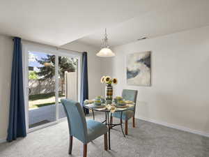 Carpeted dining room with baseboards