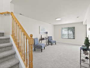Living area featuring stairs and carpet floors