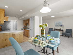 Dining area with recessed lighting, light colored carpet, and arched walkways