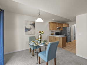 Dining space featuring light colored carpet and recessed lighting