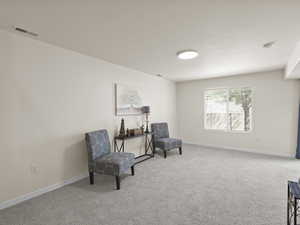 Sitting room featuring carpet floors and baseboards