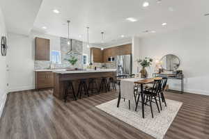Dining area with dark wood-style flooring and recessed lighting