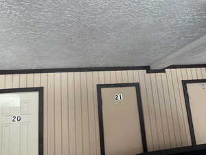 Detailed view of a textured ceiling, beam ceiling, and wooden walls