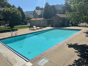 Community pool with a patio area, a mountain view, and a storage unit