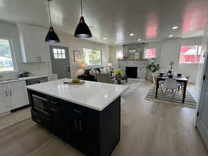 Kitchen with light countertops, white cabinets, light wood-style flooring, and recessed lighting