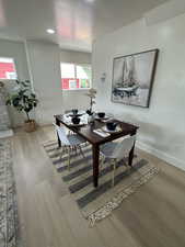 Dining space with wood finished floors and recessed lighting