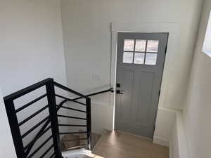 Doorway with wood finished floors and stairs
