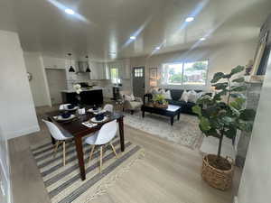 Dining room with light wood finished floors and recessed lighting