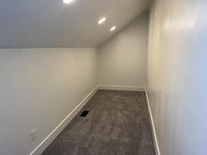 Bonus room with vaulted ceiling, recessed lighting, and dark carpet