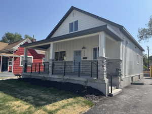 View of front of home with a porch, board and batten siding, and stone siding