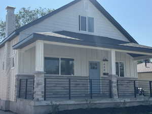 Bungalow-style house featuring board and batten siding, a chimney, and a porch