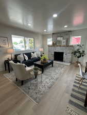 Living area with wood finished floors, a fireplace, and recessed lighting