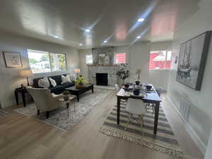 Living area featuring plenty of natural light, wood finished floors, a fireplace, and recessed lighting