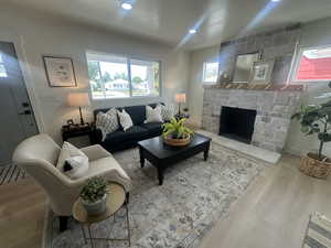Living area featuring wood finished floors, a fireplace, and recessed lighting