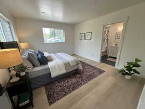 Bedroom with wood finished floors and ensuite bath