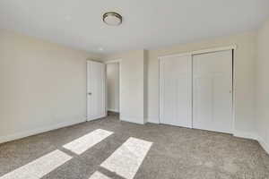 Unfurnished bedroom with carpet flooring and a closet