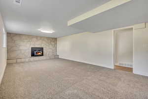 Unfurnished living room with carpet floors and a fireplace
