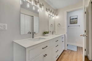 Bathroom featuring wood finished floors and double vanity