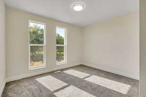 Carpeted empty room with baseboards