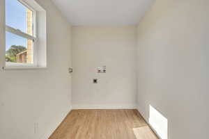 Washroom featuring hookup for an electric dryer, washer hookup, and light wood-type flooring