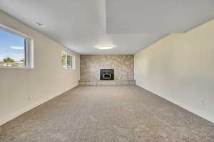 Basement featuring carpet floors, a textured ceiling, and a fireplace