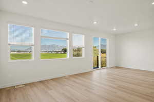 Spare room with recessed lighting, a mountain view, and light wood-type flooring