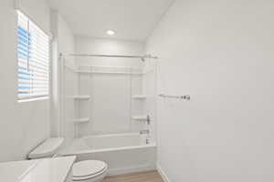 Full bathroom with shower / bathtub combination, vanity, and light wood-type flooring