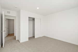 Unfurnished bedroom featuring light colored carpet, a closet, and recessed lighting