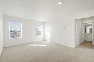 Empty room featuring light colored carpet, recessed lighting, and a textured ceiling