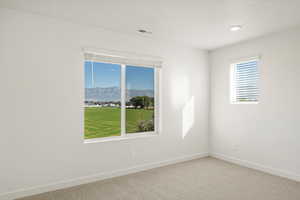 Carpeted spare room with baseboards and a mountain view