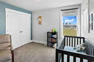 Carpeted bedroom featuring a textured ceiling and a closet