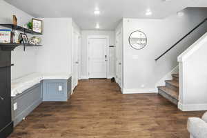 Entryway with a textured ceiling, dark wood-style floors, stairway, and a chandelier