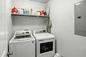 Laundry room featuring independent washer and dryer and electric panel