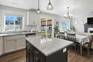 Kitchen featuring open floor plan, tasteful backsplash, a fireplace, dark wood finished floors, and a textured ceiling