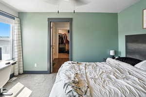 Bedroom featuring carpet flooring, a textured ceiling, and a walk in closet