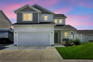 View of front facade featuring driveway, an attached garage, board and batten siding, and covered porch