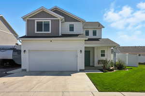 View of front facade with driveway, an attached garage, board and batten siding, and covered porch