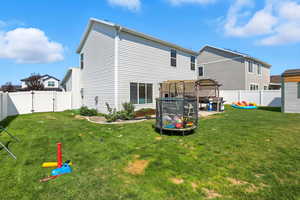 Rear view of house featuring a fenced backyard and a gate