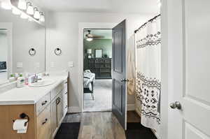 Full bathroom with connected bathroom, wood finished floors, vanity, ceiling fan, and a shower with shower curtain